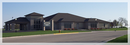 A large building with a curved roof is sitting on the side of the road.