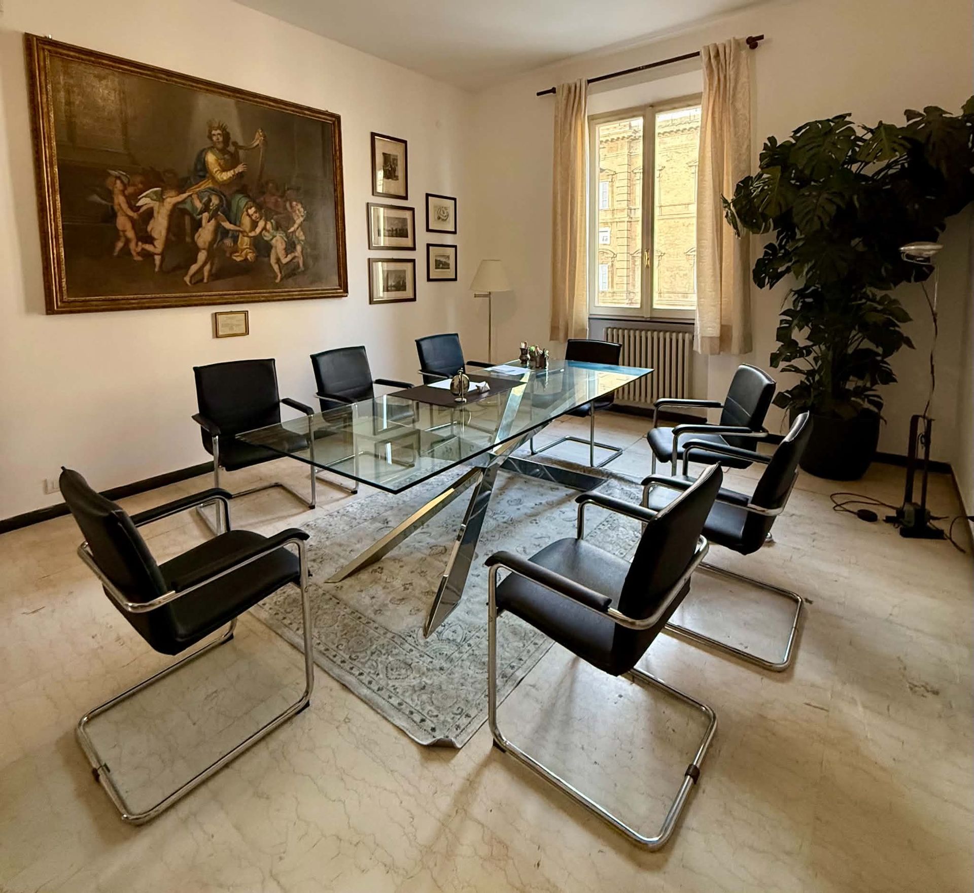 Sala riunioni dello Studio con tavolo in vetro e poltrone in pelle nera