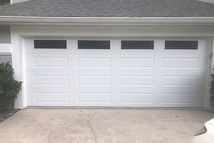 White garage door with four rectangular windows at the top.