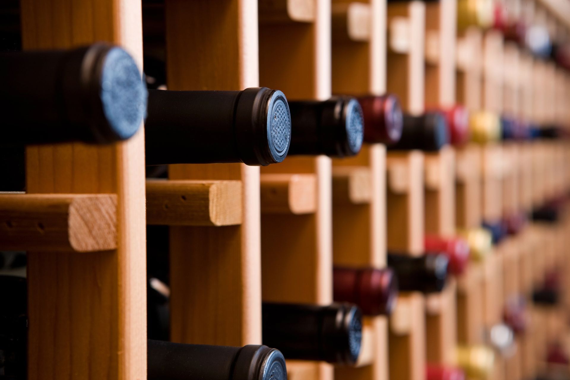 Portabottiglie in legno pieno di varie bottiglie di vino.