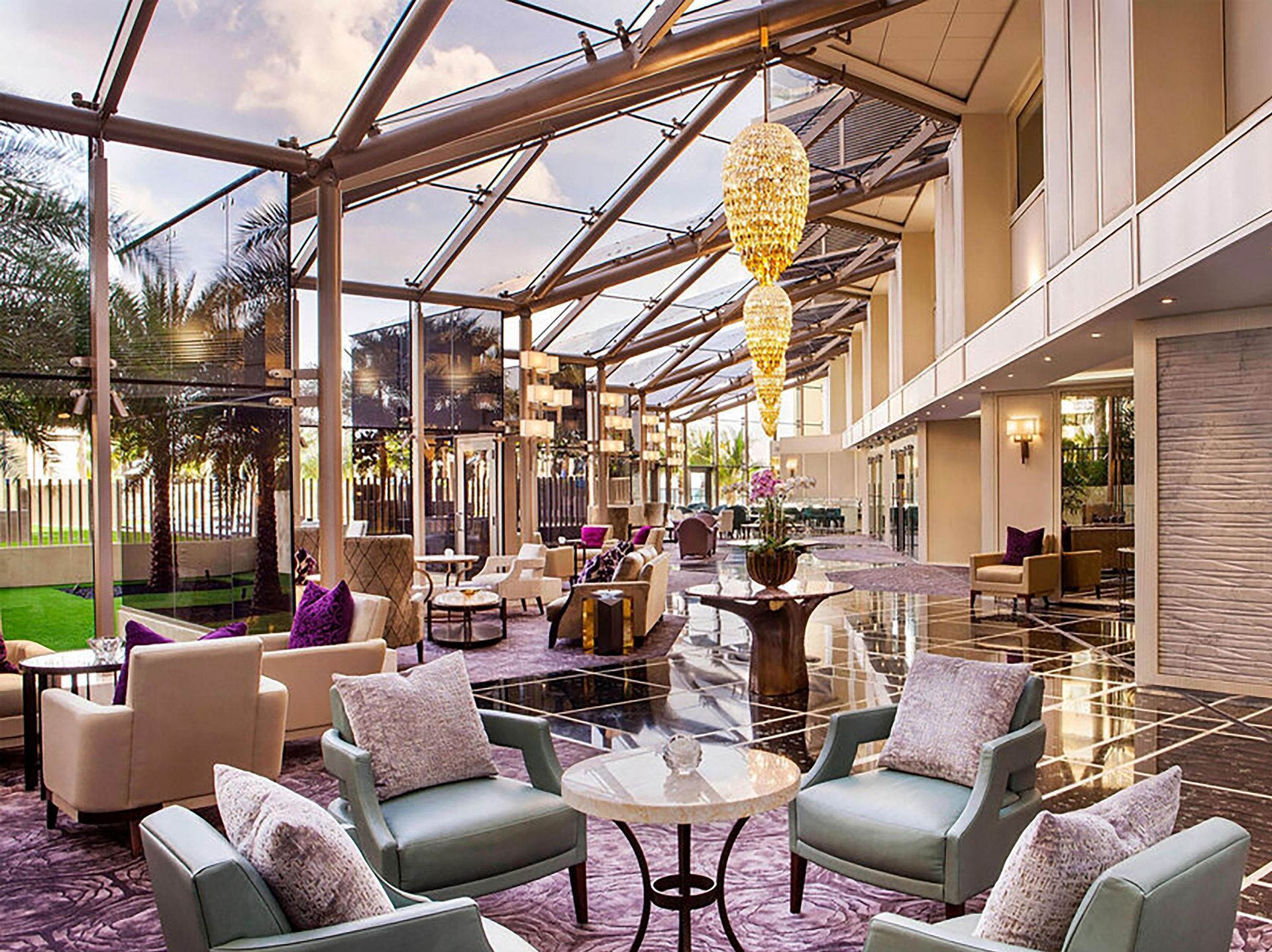 There are many chairs and tables in the lobby of a hotel.