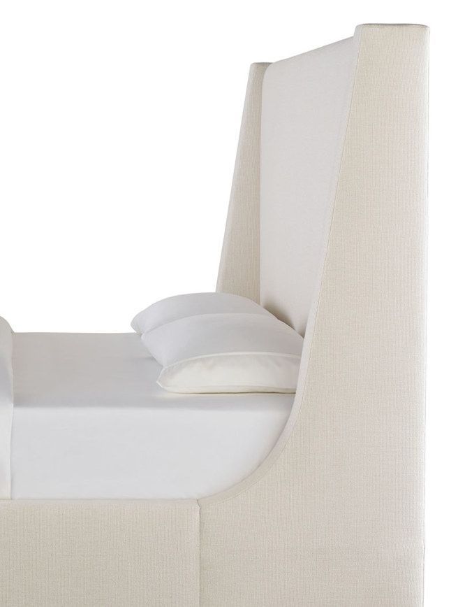 A bed with a white headboard and two white pillows on it.