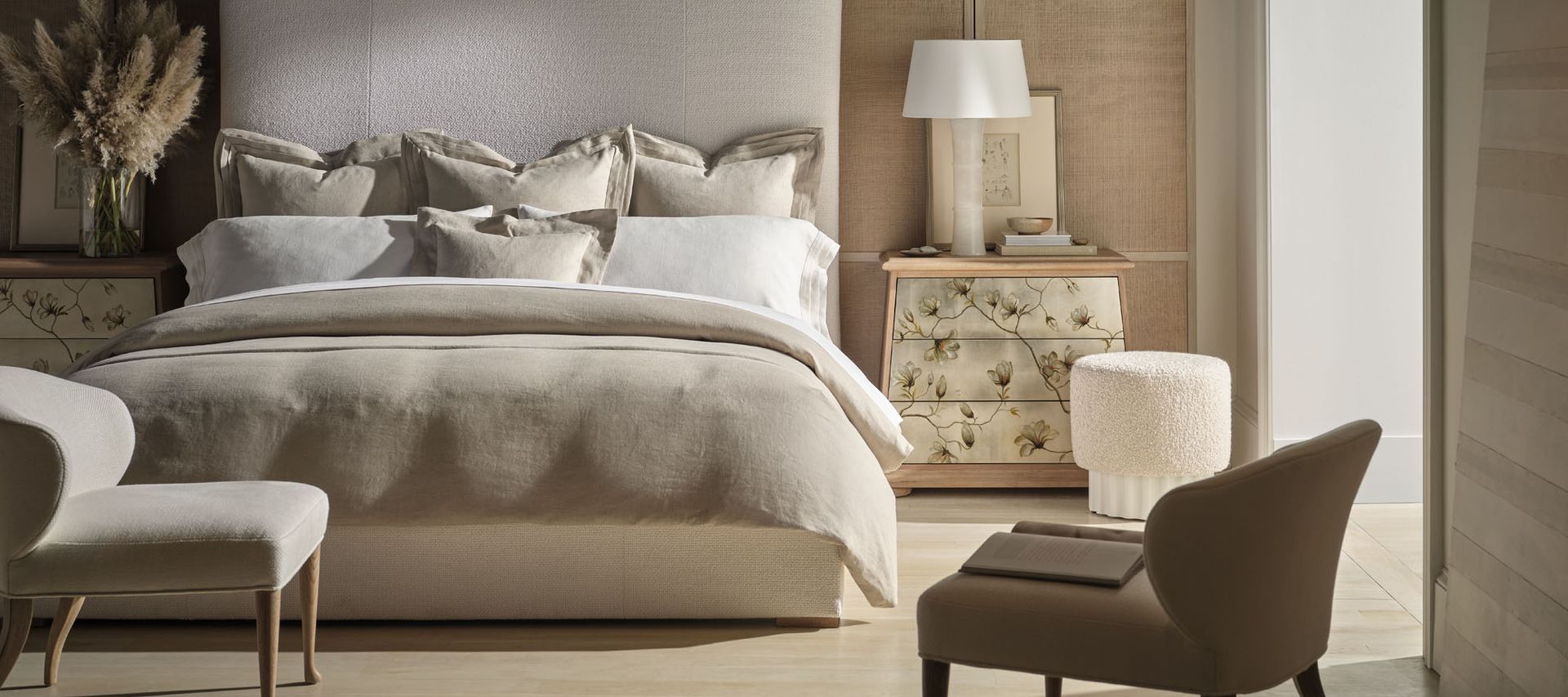 A bedroom with a bed , chair , nightstand and dresser.