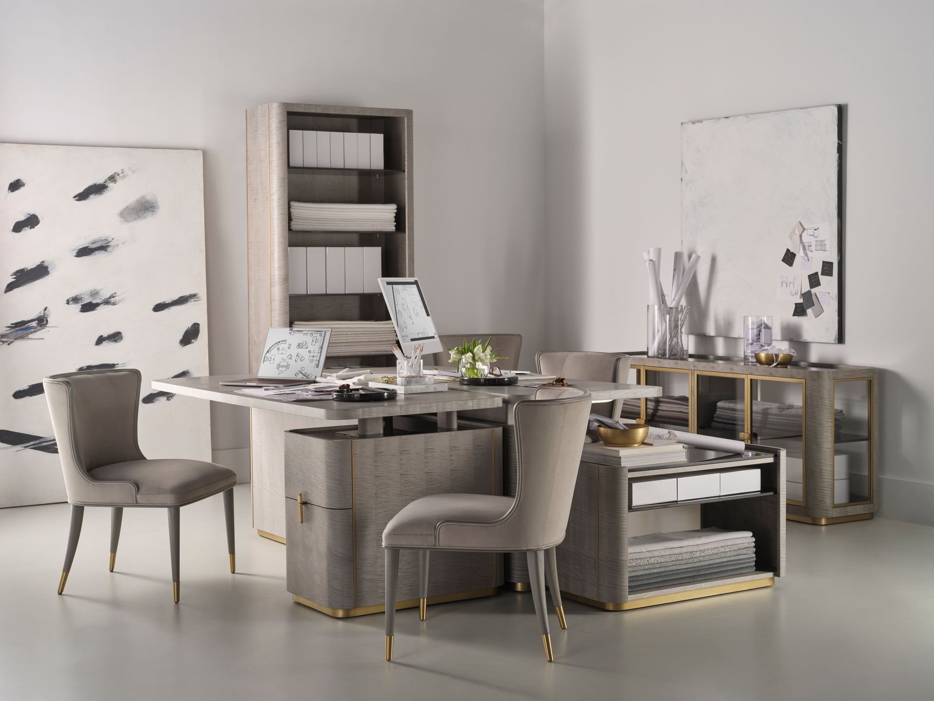 A room with a desk and chairs and a laptop on it.