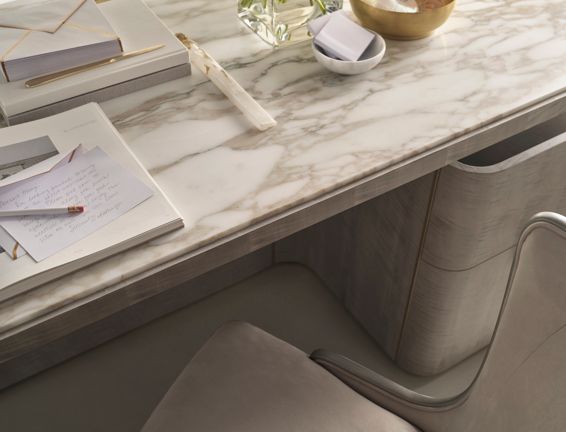 A marble desk with a notebook and a pen on it