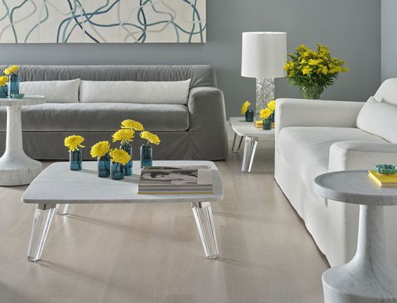 A living room with a couch and a table with yellow flowers on it