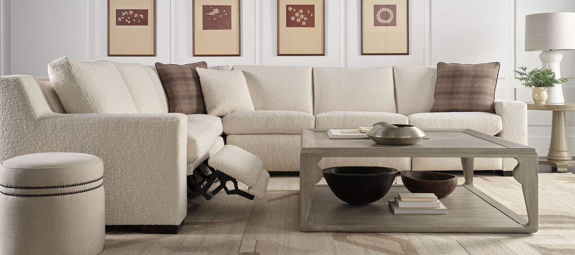 A living room with a couch , chair , coffee table and ottoman.