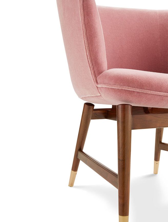 A close up of a pink chair with wooden legs