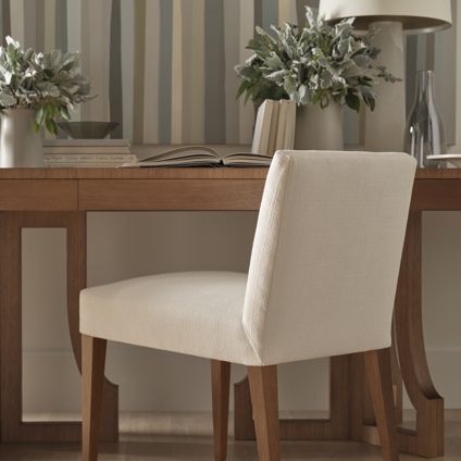 A white chair sits in front of a wooden desk