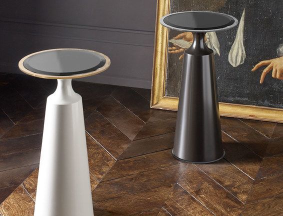 Two tables are sitting on a wooden floor in front of a painting