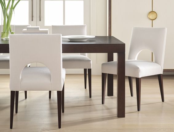 A dining room table and chairs with plates on it