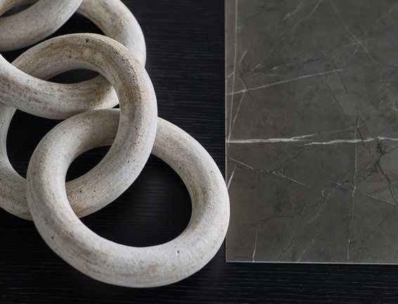Three white rings are sitting on a table next to a piece of marble.