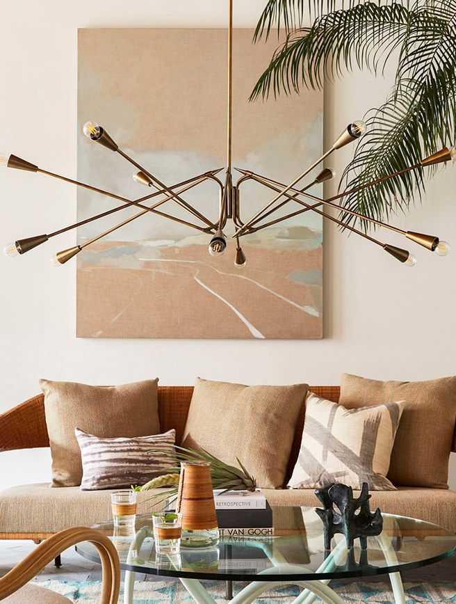A living room with a couch a coffee table and a painting on the wall