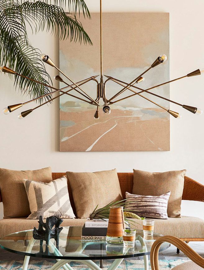 A living room with a couch a coffee table and a painting on the wall