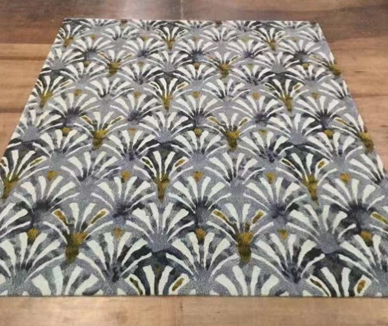 A rug with a pattern on it is sitting on a wooden floor.