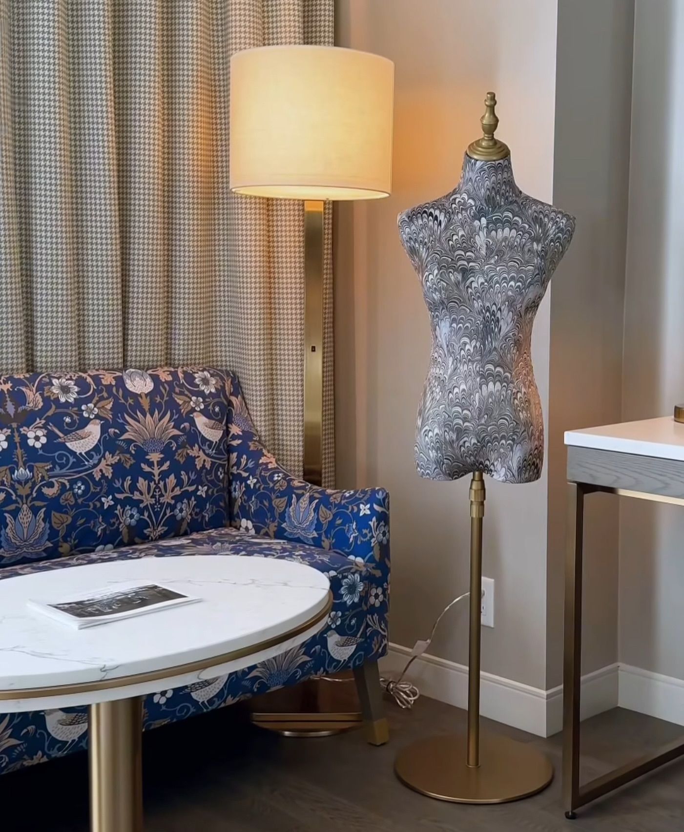 A room with a couch a table and a mannequin
