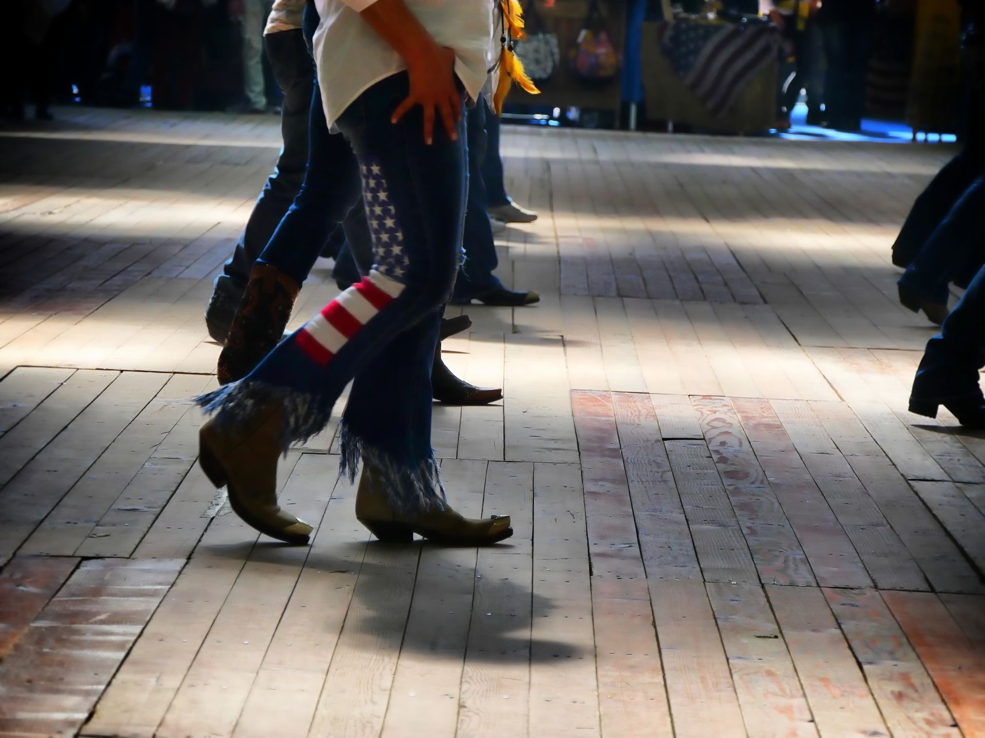 People walking on a brick sidewalk at night, one wearing striped socks and brown shoes.