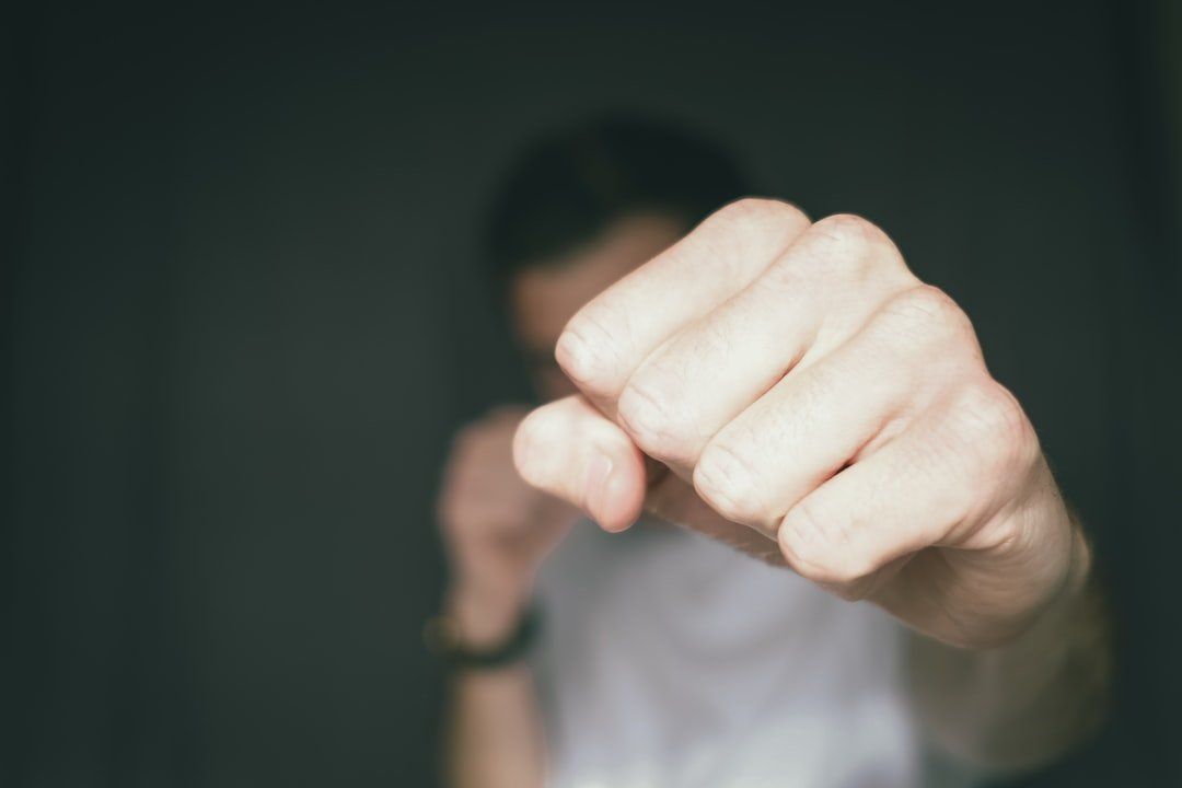 A fist punching the camera, representing the topic of battery in criminal defense law.