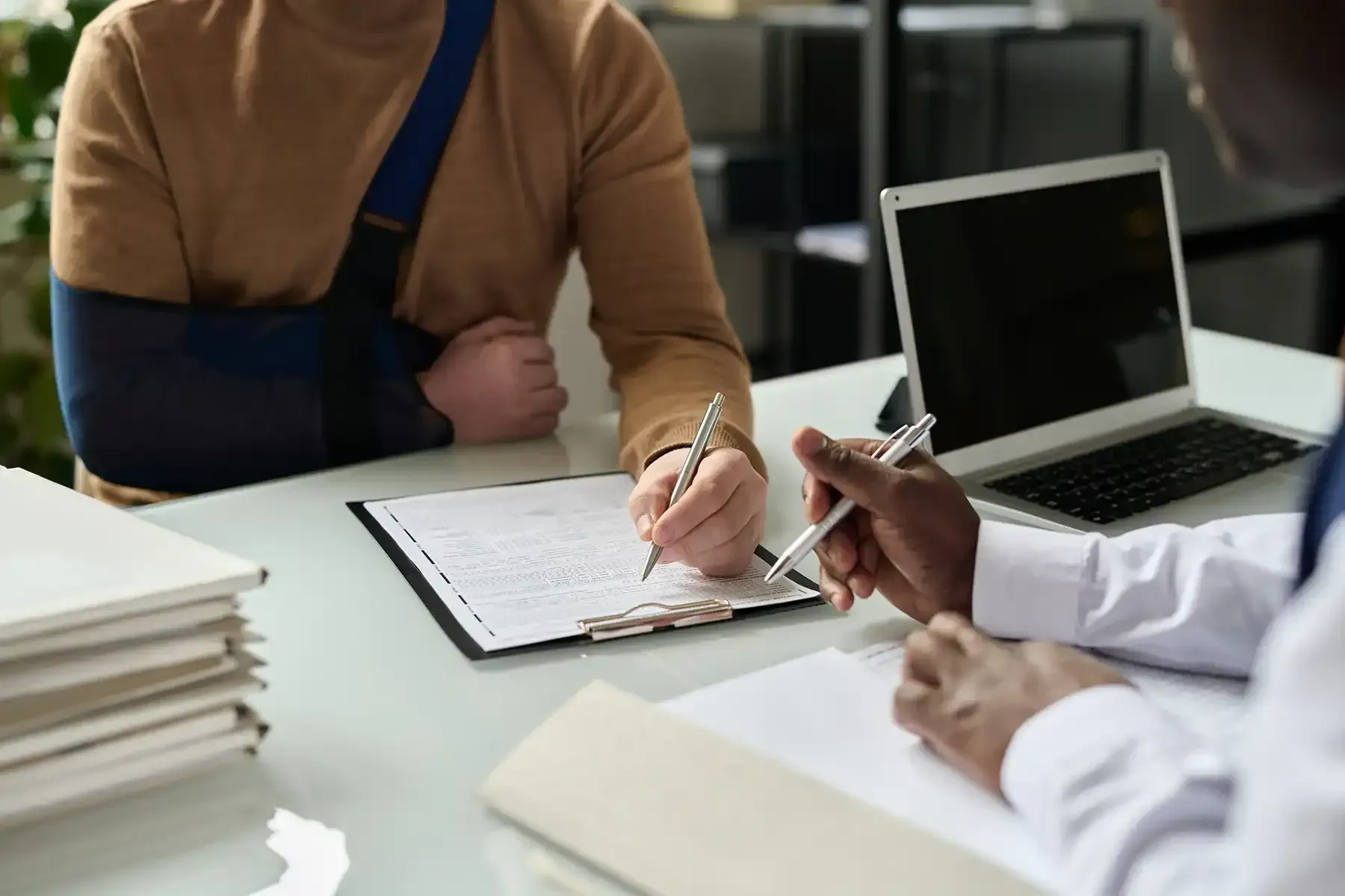 A man with a broken arm is sitting in an office, representing the topic of personal injury law.