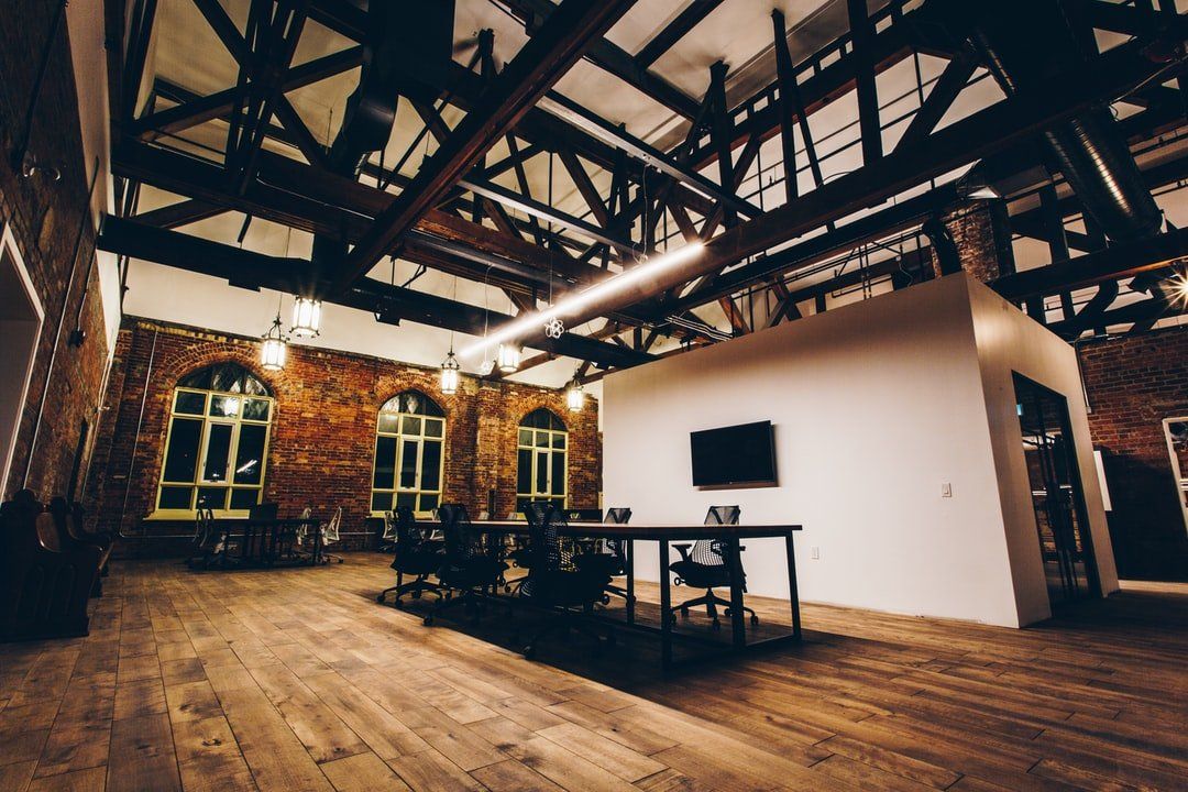 A large room with a wooden floor and a table and chairs in it.
