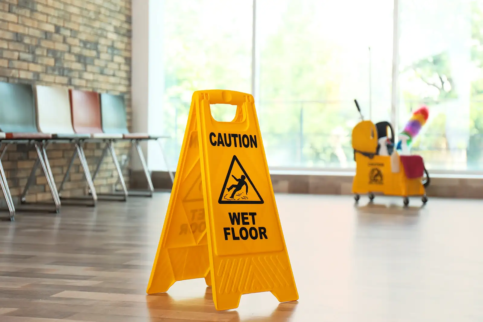 A yellow wet floor sign is sitting on the floor of a business, representing the topic of slips and falls in personal injury law.