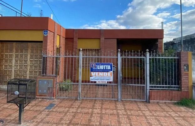 Casa con portón metálico en venta, letrero 
