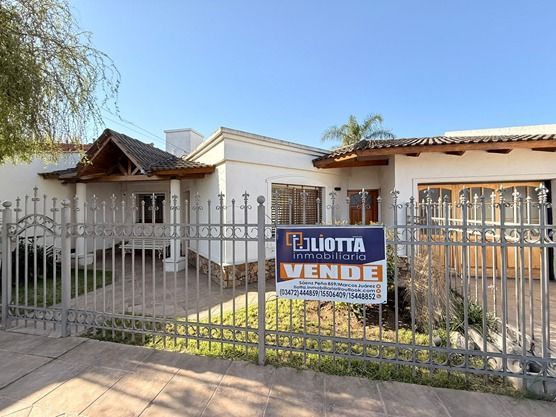 Casa en venta detrás de una puerta de metal, con un cartel de 