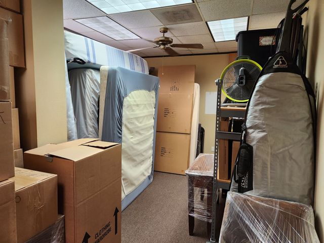 A room filled with boxes and a mattress.