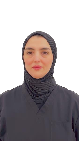 Portrait of a woman in a dark headscarf and blouse against a plain white background