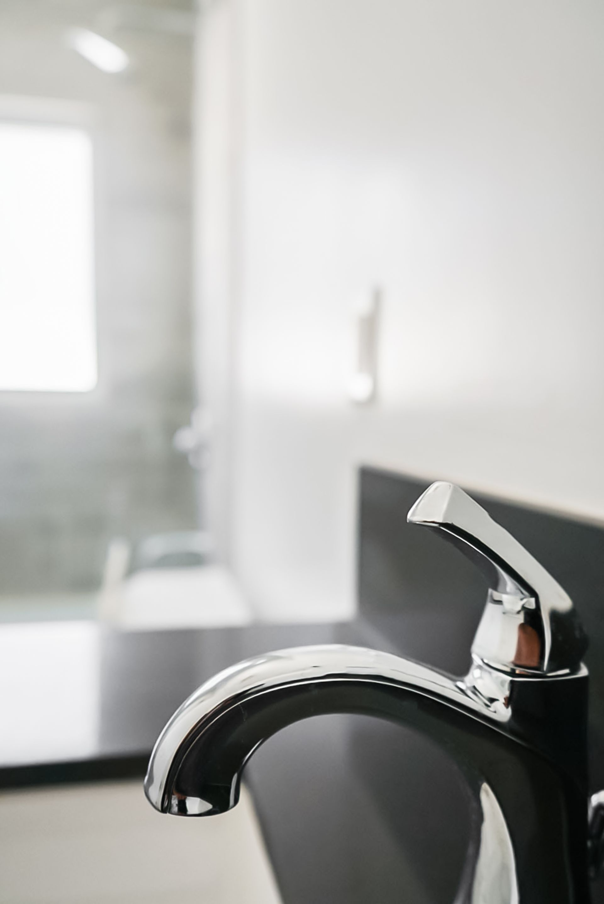 Chrome bathroom faucet in a bright, modern sink area
