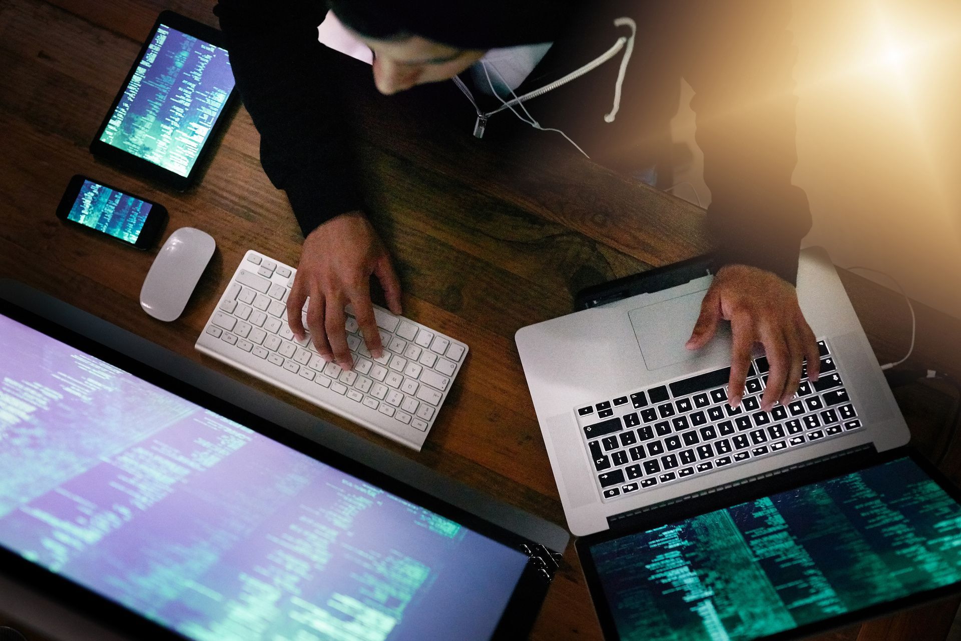 A man is typing on a laptop computer while sitting at a desk.