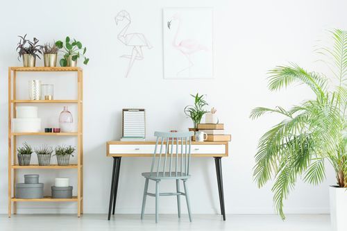 There is a desk with a chair and a bookshelf in the room.