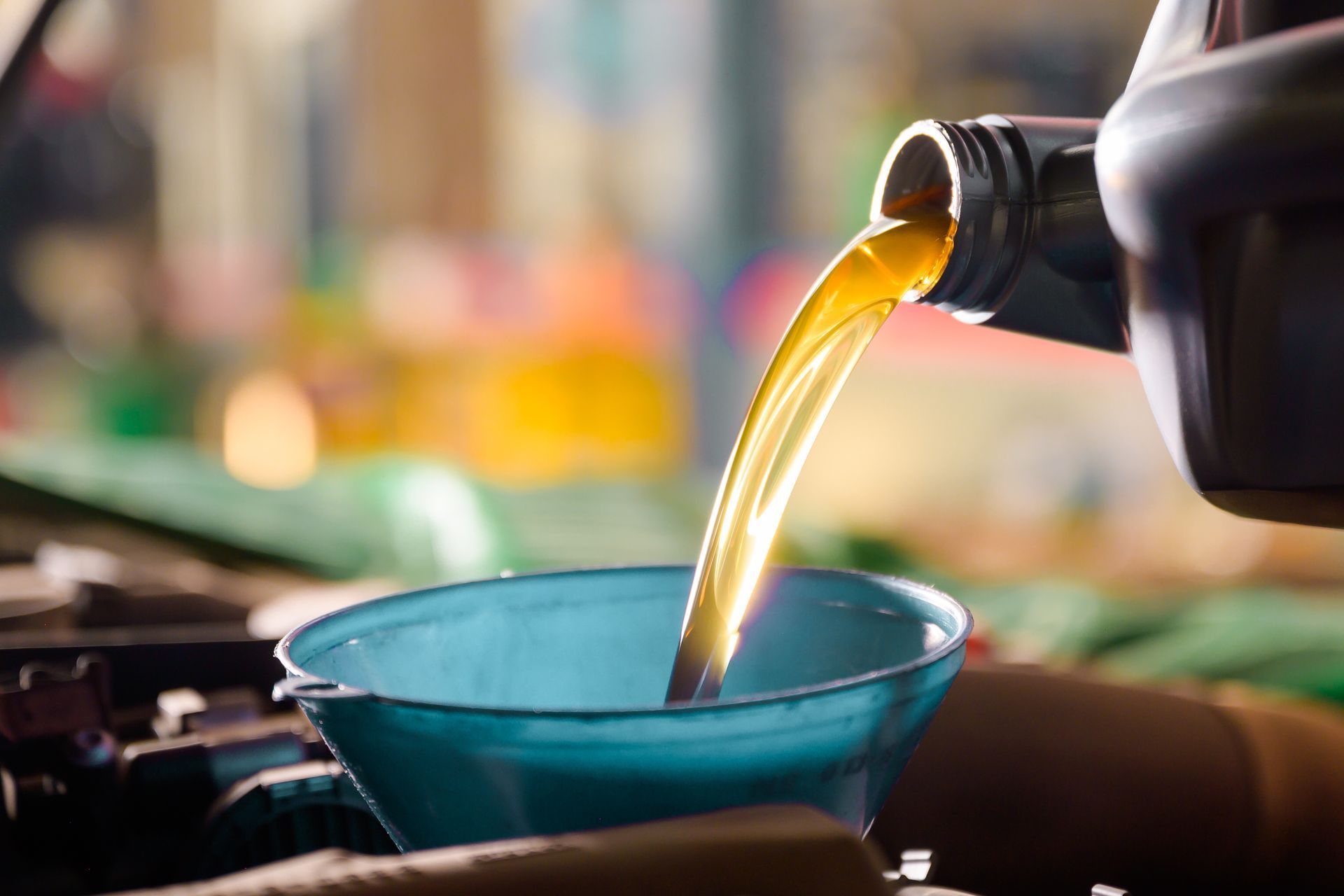 Oil pouring into a blue bowl from a bottle on a countertop