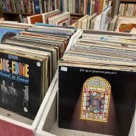Bins of vinyl records in a shop, with album covers visible in the foreground.