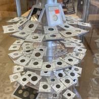 Display of many paper currency notes arranged in a spiral on a glass tabletop