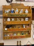 Wooden shelf display with plates labeled Chinese Cuisine, Indian Cuisine, and Thai Cuisine.