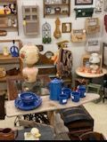 Shelves of blue pottery and pottery tools in a rustic craft studio display