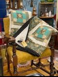 Patchwork quilt draped over a wooden chair in a cozy room, with bookshelves in the background