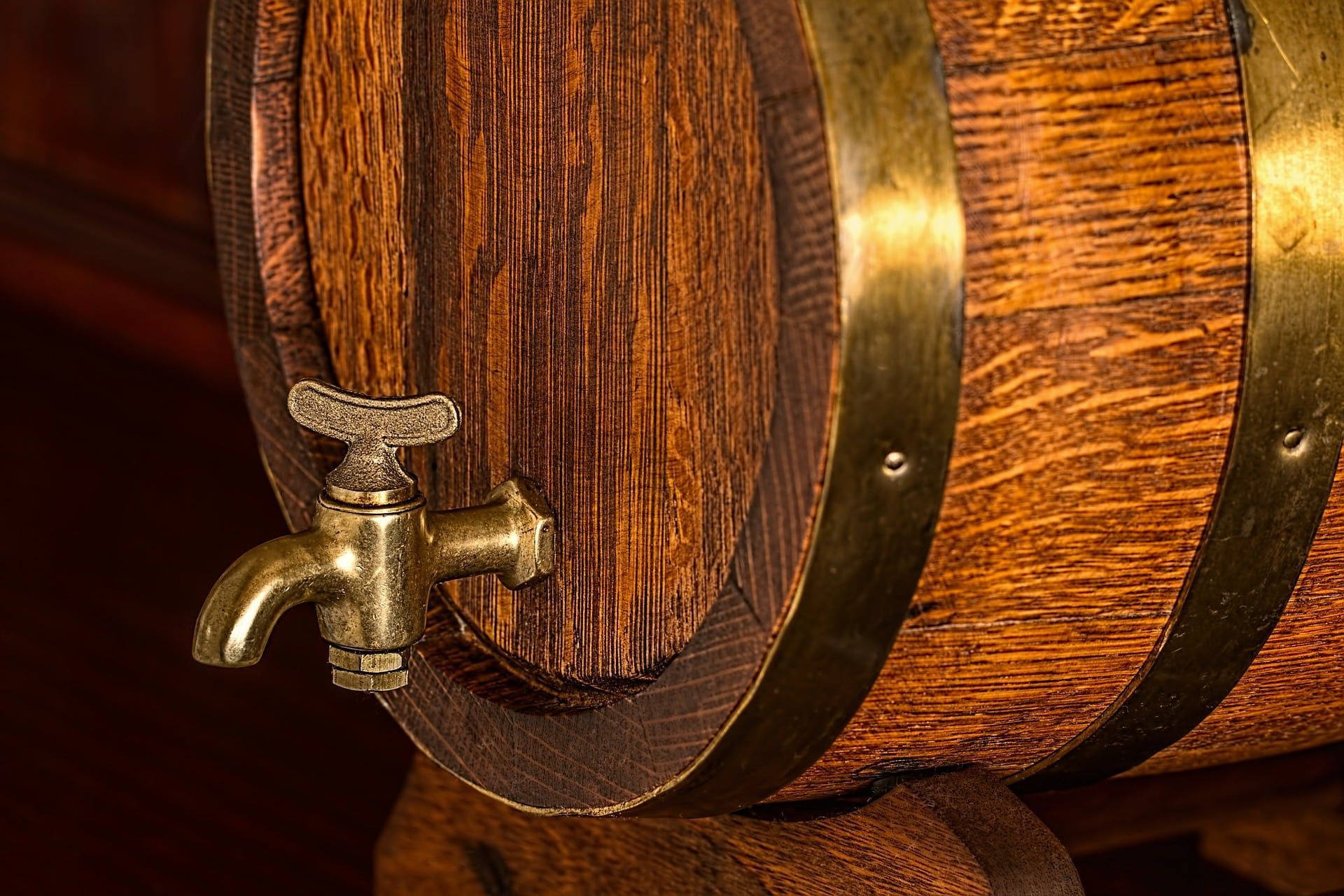 Wooden barrel with brass faucet and bands.