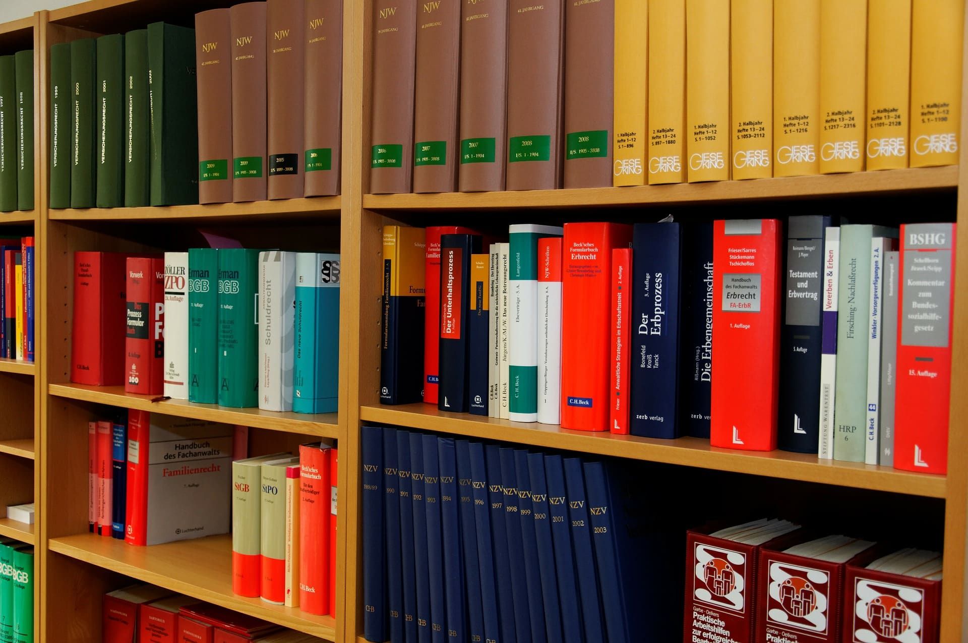 Bookshelves filled with books of varying colors in a library setting.