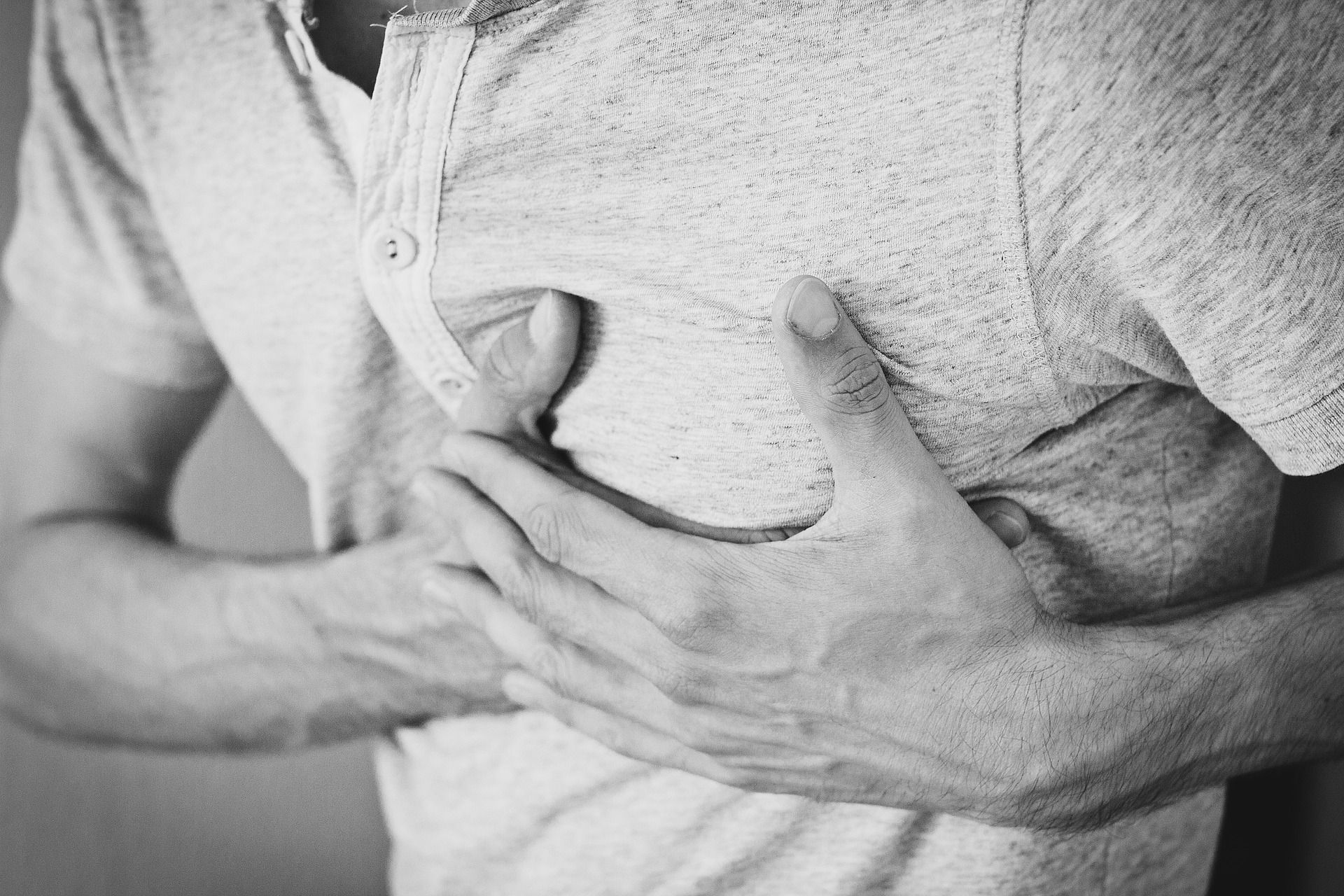 Man clutching his chest, possibly experiencing chest pain.