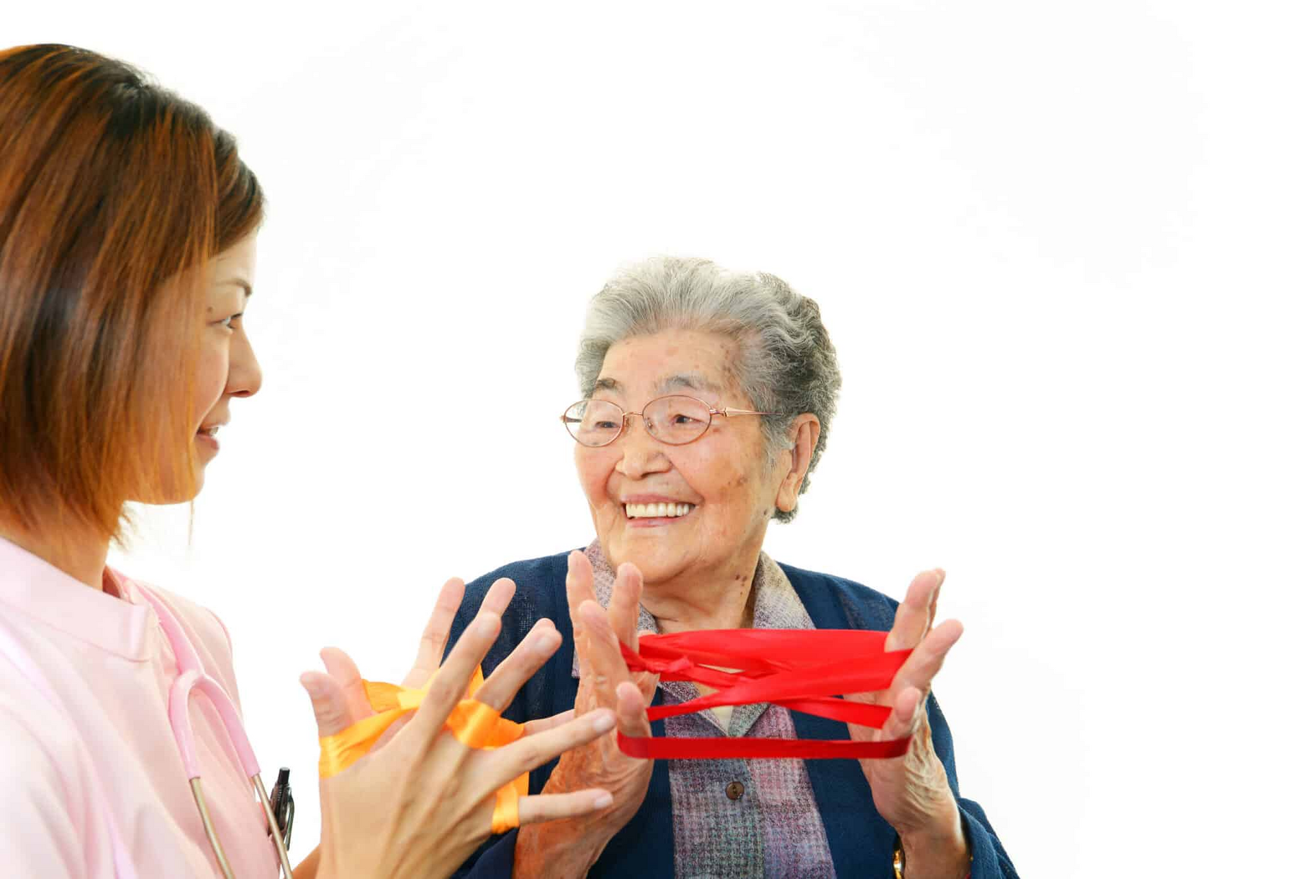 Nurse assisting elderly woman with physical therapy using resistance bands.