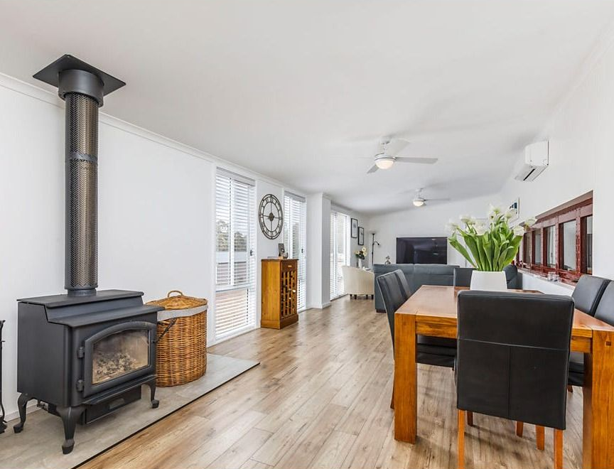 Bright Open Dining and Living Room with Wood Floors, a Black Wood Stove — Rivbuild In Uranquinty, NSW