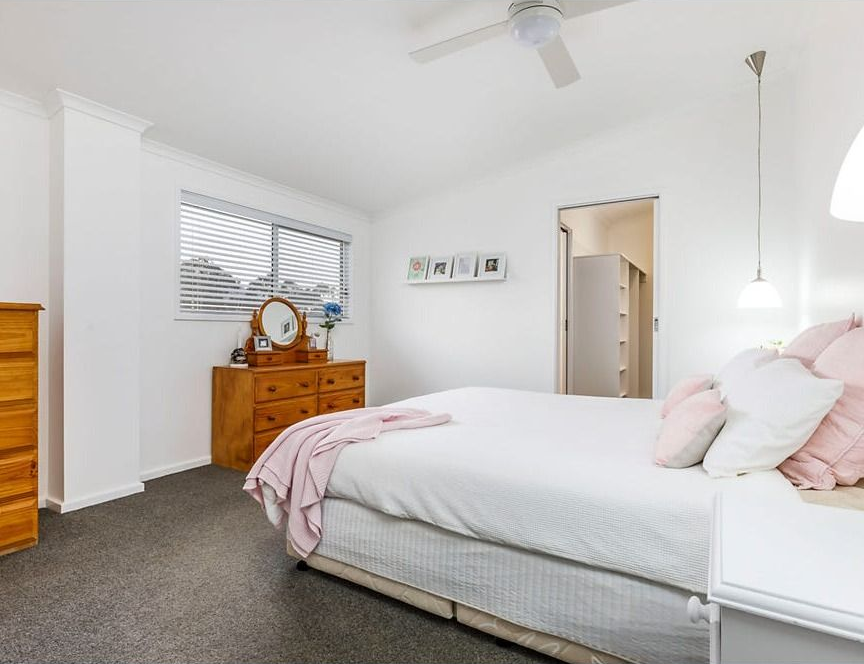 Bright Bedroom with A White Bed, Dresser, Window Blinds, and Gray Carpet — Rivbuild In Uranquinty, NSW