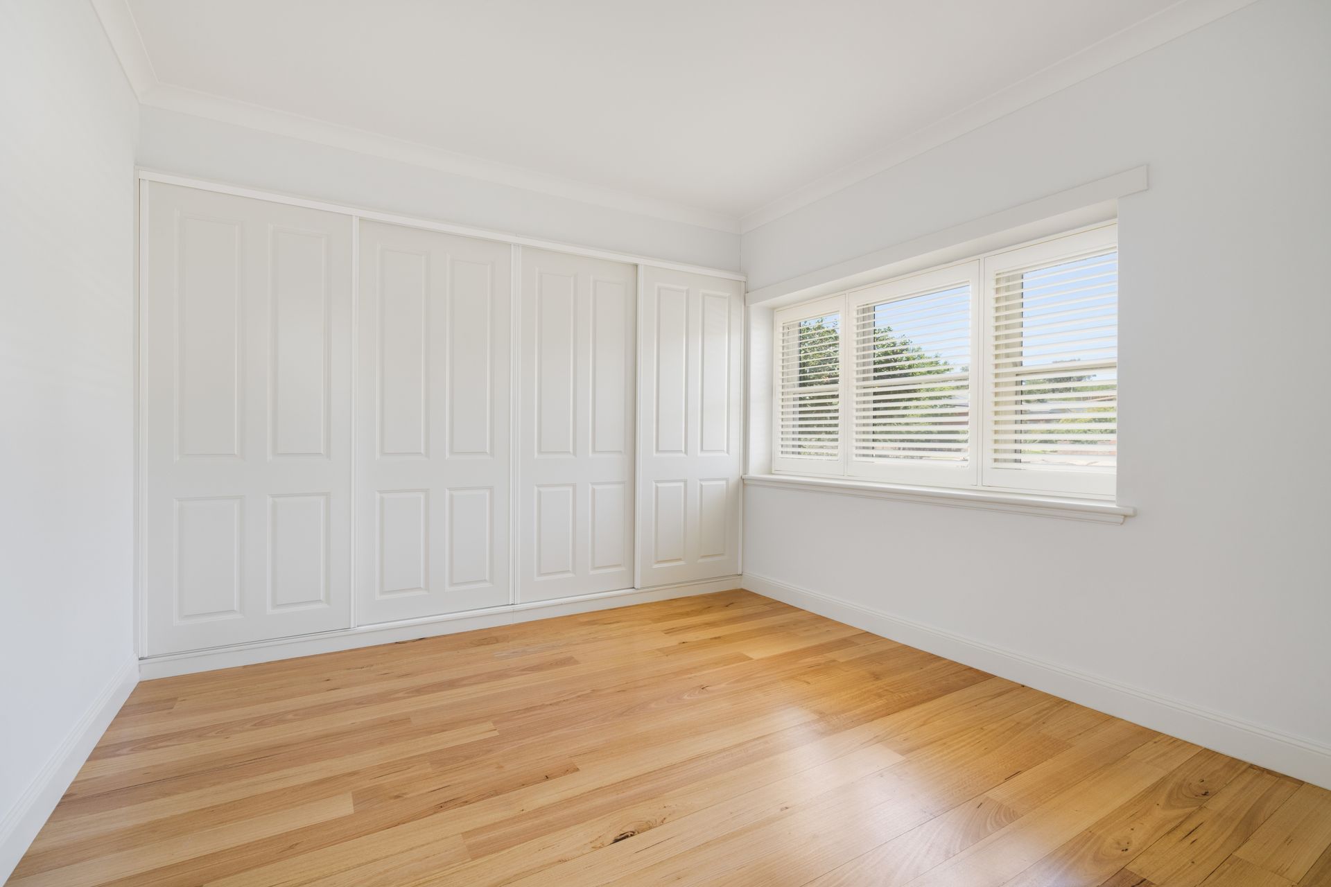 Empty White Bedroom with Wood Floors, Built-In Closet Doors — Rivbuild In Uranquinty, NSW