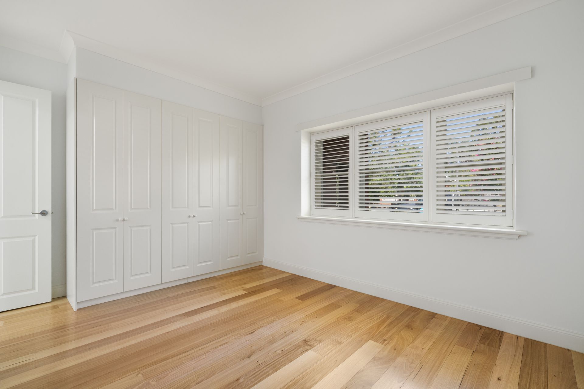 Bright Empty Bedroom with Hardwood Floors, White Walls — Rivbuild In Uranquinty, NSW