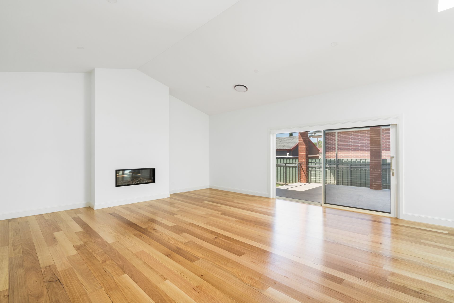 Bright Empty Living Room with Hardwood Floors, White Walls — Rivbuild In Uranquinty, NSW