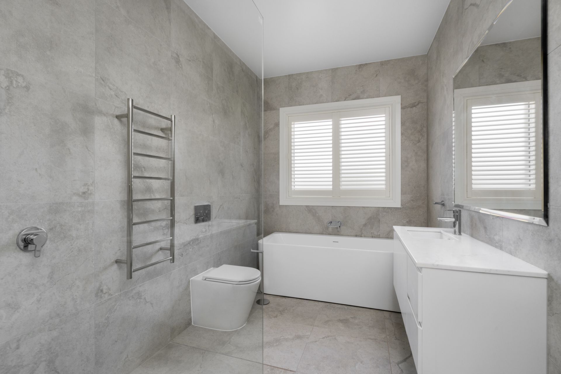 Modern Gray-Tiled Bathroom with A Bathtub, Towel Rack — Rivbuild In Uranquinty, NSW