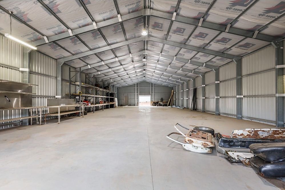 Large Empty Metal Warehouse Interior with A High Arched Roof — Rivbuild In Uranquinty, NSW