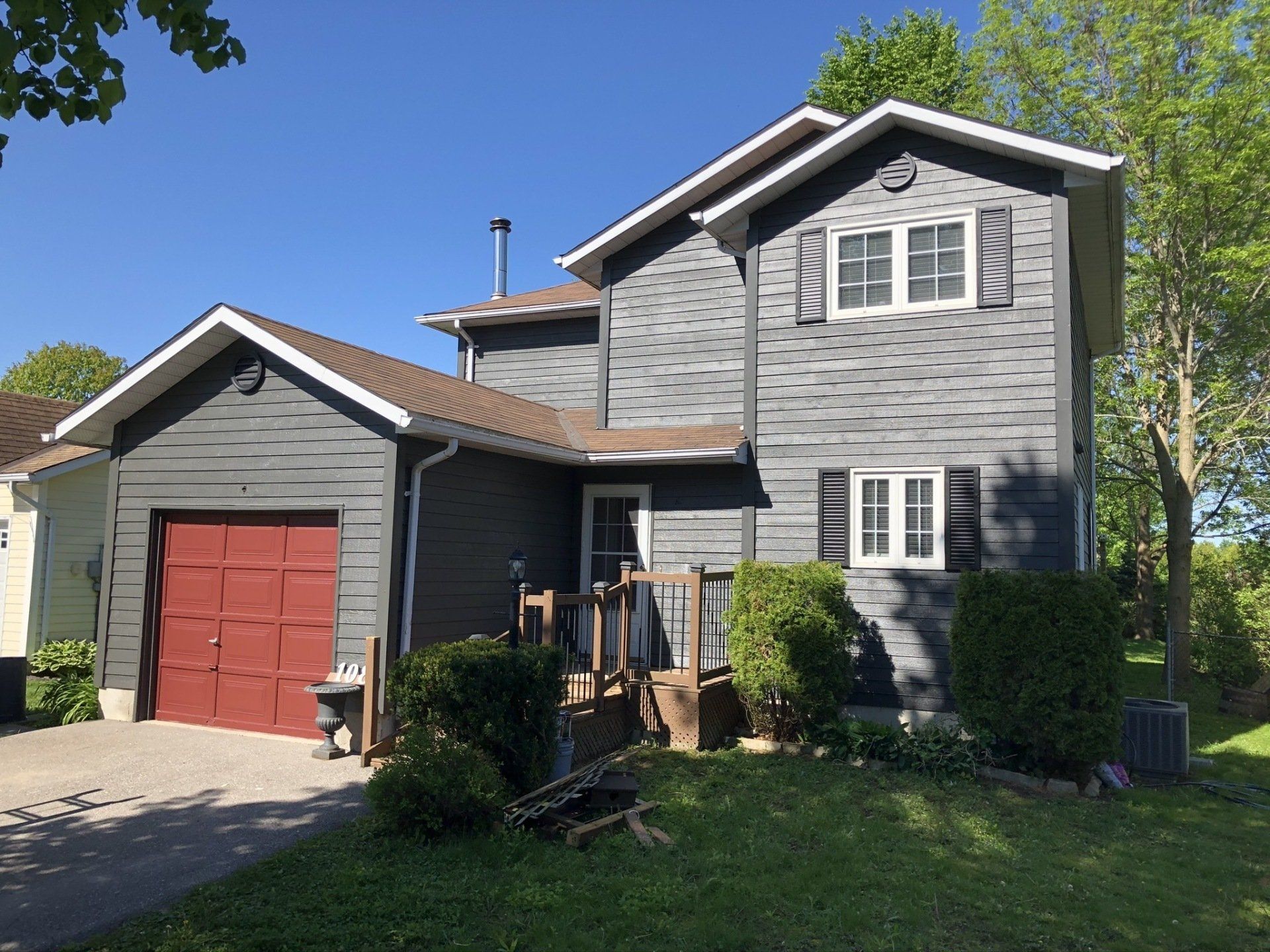 A large gray house with a red garage door customed painted exterior.